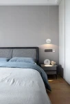 Lampa wisząca Quiberon 1xLED 8W w kolorze białym, zawieszona nad łóżkiem, z okrągłym kloszem. W tle widoczna szara ściana oraz nowoczesne meble. Oświetlenie delikatnie podkreśla aranżację sypialni.