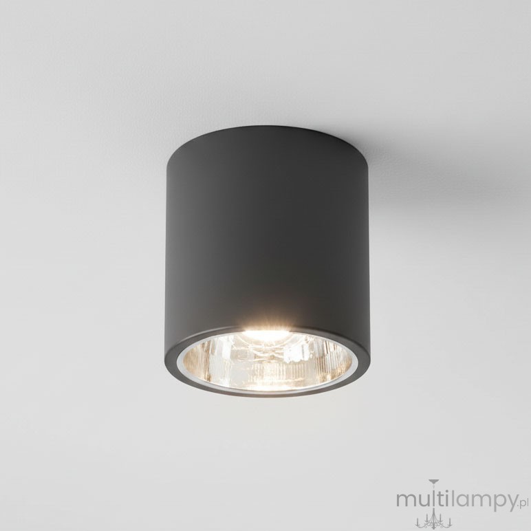 Lampa sufitowa natynkowa Jupiter 17 w kształcie czarnej tuby, z pojedynczym gniazdem E27. Umieszczona na białym suficie, emitująca ciepłe światło przez przezroczystą szybkę. Prosta, cylindryczna forma, idealna do nowoczesnych wnętrz.