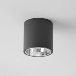 Lampa sufitowa natynkowa Jupiter o cylindrycznym kształcie, w kolorze czarnym. Posiada jedną oprawę E27 oraz szklany klosz, który odbija światło, montowana na suficie. Widok z dołu, ukazujący detale wykończenia i otwarcie na żarówkę.