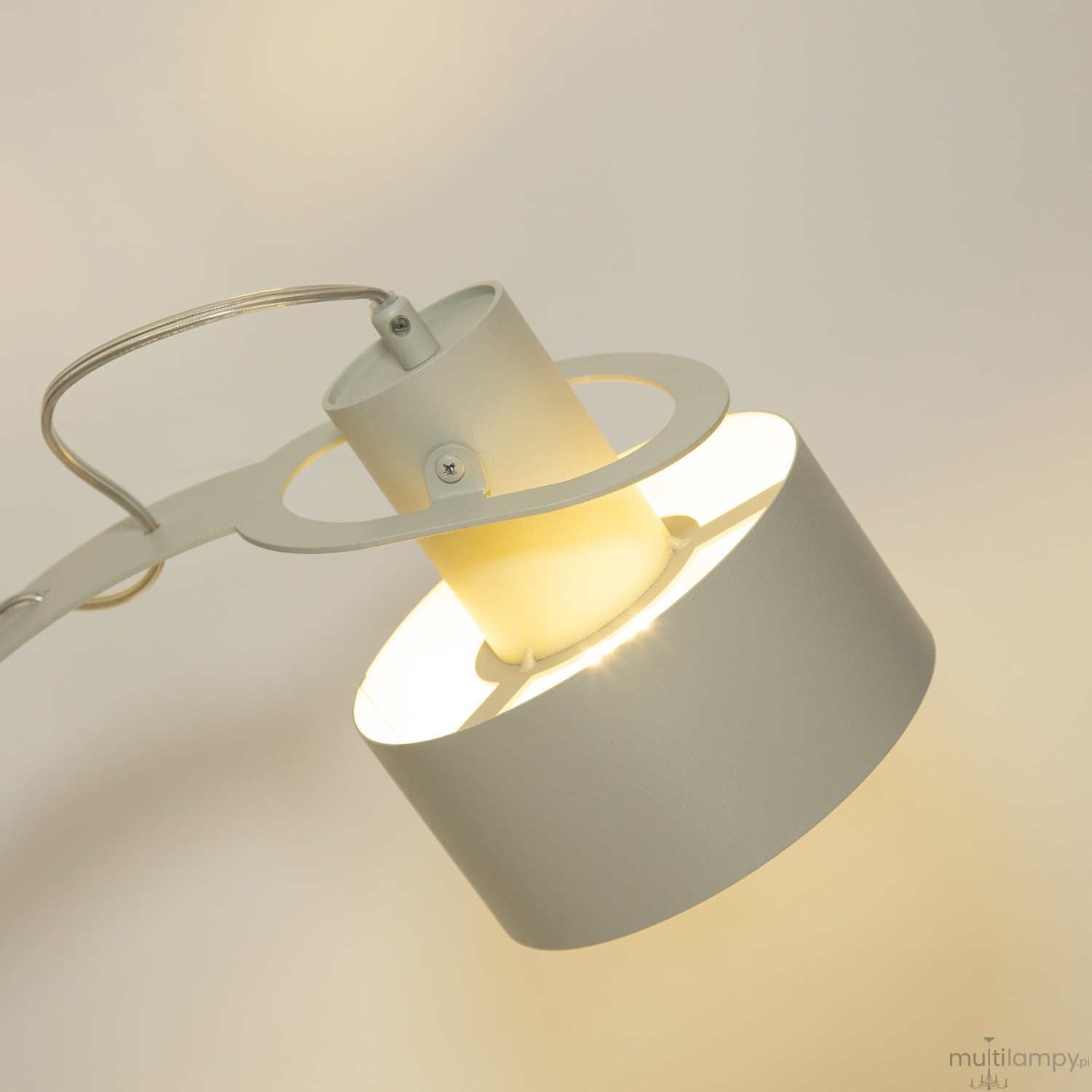 Lampa stołowa Rif 1xE27 w odcieniu szaro-beżowym, z okrągłym kloszem i metalową konstrukcją. Ujęcie z góry, pokazujące źródło światła oraz charakterystyczny kształt. Jasne światło wydobywające się z klosza.