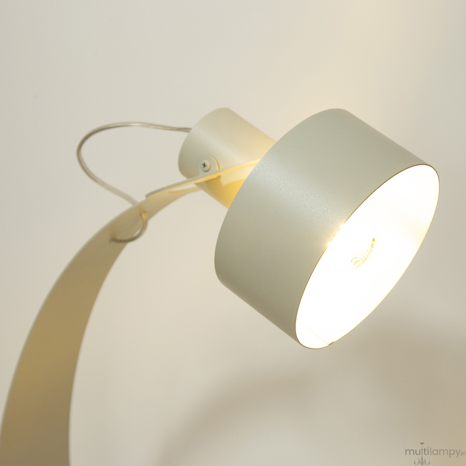 Lampa stołowa Rif z metalowym kloszem w odcieniu szaro-beżowym, z jednym źródłem światła E27. Ujęcie z góry, zbliżenie na klosz i mocowanie. Kształt zaokrąglony, z widocznym drucikiem mocującym.