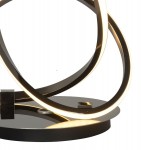 Lampa stołowa Bandol w kolorze czarnym z chromowanymi akcentami, z podświetleniem LED 18W. Okrągła podstawa z błyszczącego materiału, dwie stylowe, splątane obręcze emitujące ciepłe światło. Zbliżenie na detal konstrukcji.