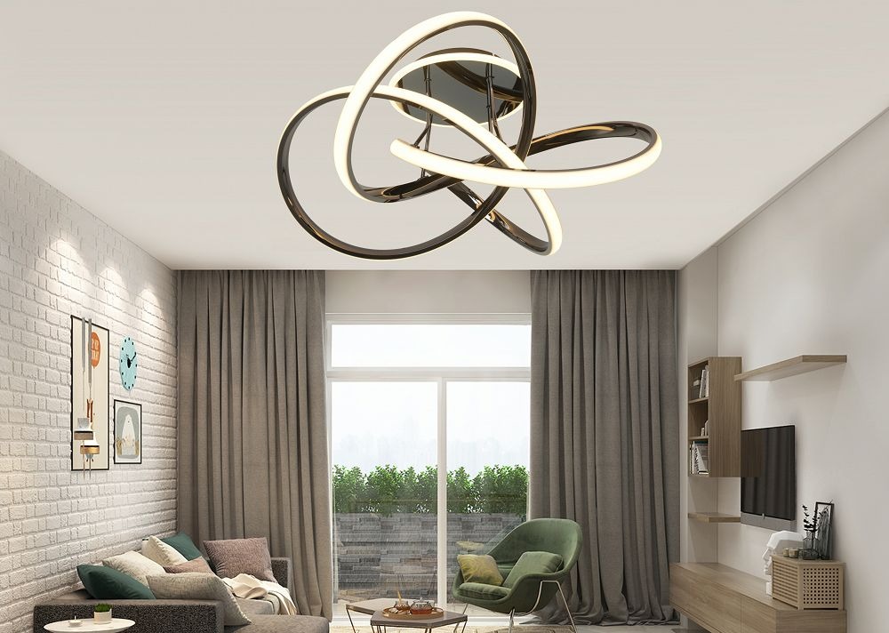 Lampa sufitowa Bandol 1xLED 56W w kolorze czarnym i chromowanym, z unikalnym, nowoczesnym kształtem składającym się z falujących pierścieni. Zawieszona na białym suficie w stylowym wnętrzu z dużymi oknami i zasłonami.