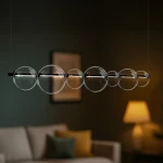 Lampa wisząca LED Atola 19W 4000K w kolorze czarnym, z sześcioma przezroczystymi kulami na metalowej konstrukcji. Produkt zawieszony w poziomie, w tle widoczny przytulny kącik wypoczynkowy z kanapą i lampą.