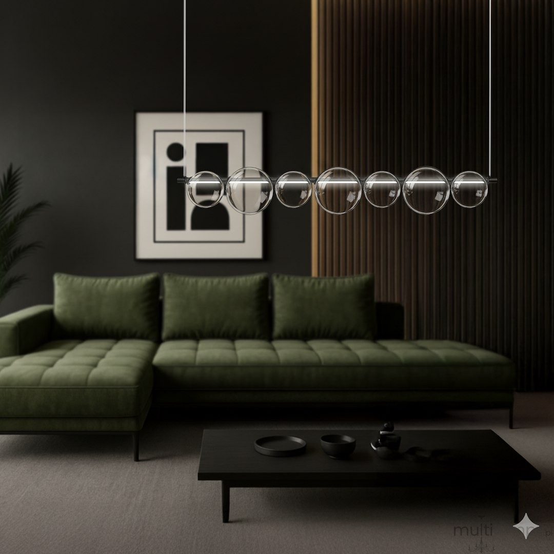 Lampa wisząca LED Atola 19W 4000K w kolorze czarnym, zawieszona nad zieloną kanapą, z sześcioma okrągłymi kloszami. Tło w odcieniach czerni i drewna, z grafiką na ścianie. Wnętrze nowoczesne, eleganckie.
