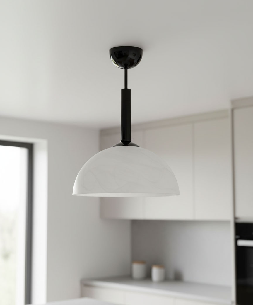 Czarna lampa wisząca Klara z białym kloszem w kształcie półkuli, zawieszona na czarnym stelażu. Widoczny detal montażowy na suficie. Lampa w minimalistycznej kuchni z jasnymi meblami.