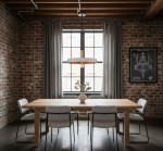 Lampa wisząca Dario z białym kloszem i złotą oprawą, zawieszona nad drewnianym stołem. W tle widoczna ceglana ściana i okna z zasłonami, a na stole wazon z roślinami. Produkt w aranżacji nowoczesnej jadalni.