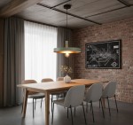 Lampa wisząca Dario w kolorze szałwiowym z metalowym złotym wykończeniem. Okrągła oprawa z widoczną żarówką, zawieszona nad drewnianym stołem w nowoczesnej jadalni. Tło z ceglanej ściany i zasłonami w neutralnych odcieniach.