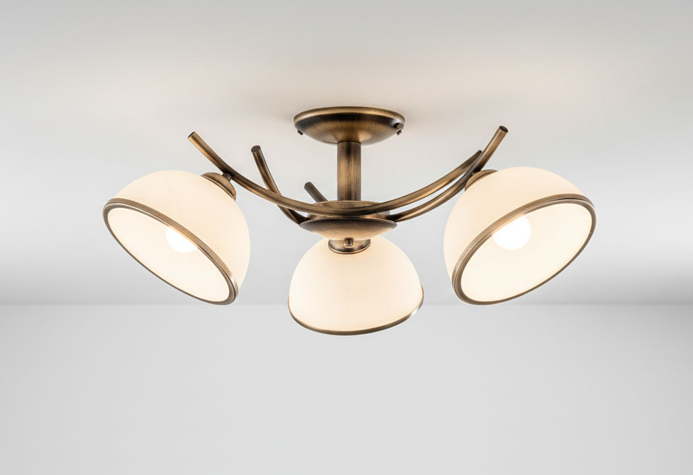 Lampa sufitowa Altea 3-punktowa w kolorze patyny. Posiada trzy klosze w kształcie półkul, wykonane z mlecznego szkła, zamocowane na eleganckich, metalowych ramionach. Ujęcie z góry, produkt zamontowany na suficie.