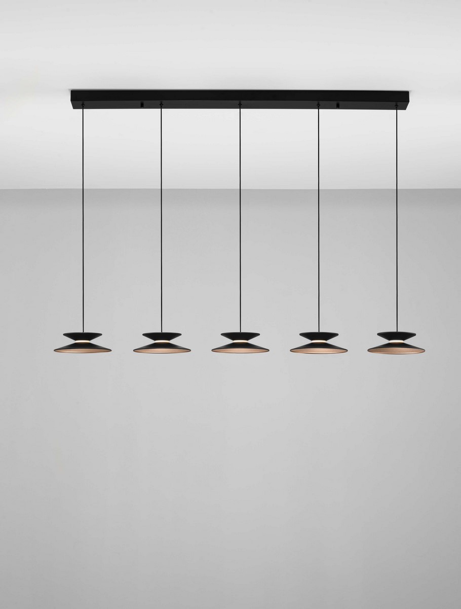 Lampa wisząca Guanay z pięcioma źródłami LED 24W. Czarno-złote klosze w kształcie dysków zawieszone na cienkich linkach, montowane na prostokątnej podstawie. Prosty, nowoczesny design, idealna do aranżacji wnętrz. Tło w jasnym kolorze.