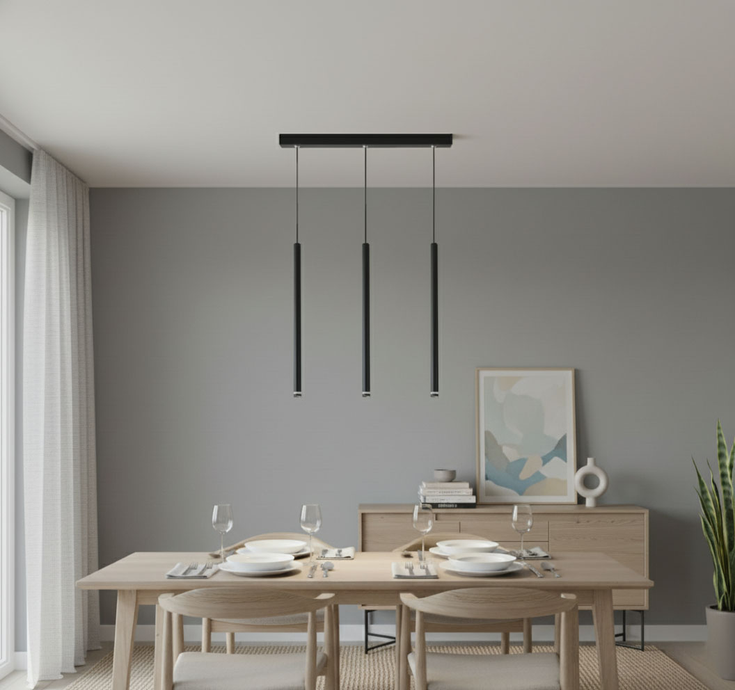 Lampa wisząca Piero w kolorze czarnym, z trzema cylindrycznymi kloszami, zawieszona na cienkich linkach, umieszczona nad drewnianym stołem w nowoczesnej jadalni, z szarym tłem i minimalistycznymi dekoracjami.