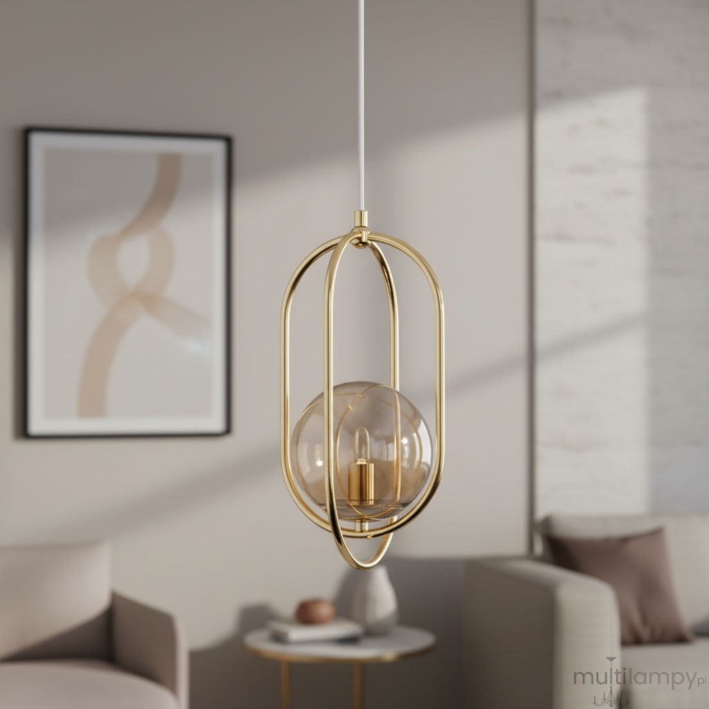 Lampa wisząca Binar 1-punktowa w kolorze złotym, z transparentnym kloszem w kształcie kuli, zawieszona na białym przewodzie. Widoczny elegancki metalowy stelaż oraz podstawa lampy. Tło w stonowanych kolorach, z elementami aranżacji wnętrza.