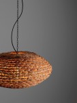 Lampa wisząca Guardia z materiału w kolorze hiacynt wodny, o owalnym kształcie, z widocznym sznurkiem i łańcuchem. Wnętrze lampy podświetlone ciepłym światłem, zawieszona w górnej części na tle szarym. Idealna do nowoczesnych wnętrz.
