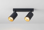 Lampa sufitowa Eris z dwoma punktami świetlnymi w kolorze czarnym z wewnętrzną złotą powłoką. Ujęcie z dołu, pokazujące dwa cylindryczne reflektory zamontowane na prostokątnej podstawie. Oświetlenie skierowane w dół, na jednolitym tle.