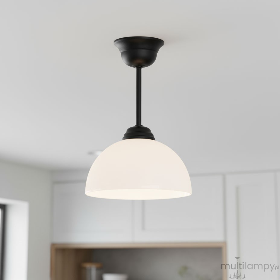 Lampa wisząca Frella z czarnym metalowym stelażem i białym, półkulistym kloszem z mlecznego szkła. Produkt zawieszony na długim pręcie, idealny do nowoczesnych wnętrz. Ujęcie z dołu, w jasnym otoczeniu kuchennym.