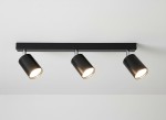 Czarna lampa sufitowa (spot) Bardo z trzema punktami świetlnymi, zamocowana na prostokątnej, chromowanej podstawie. Lampy o cylindrycznym kształcie skierowane w dół, na tle białego sufitu.