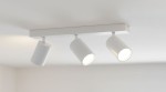 Bardo lampa sufitowa (spot) 3-punktowa, biała z chromowanymi detalami. Zawiera trzy regulowane reflektory w cylindrycznych oprawach, zamontowana na prostokątnej podstawie, umieszczona na białym tle, w górnej części pomieszczenia.