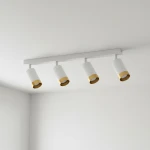 Lampa sufitowa Arras z czterema reflektorami GU10, z białymi kloszami z fakturą i złotymi obrzeżami, zamontowana na białej listwie. Klosze ustawione równolegle do sufitu, tworząc nowoczesny design. Tło jasne, proste.