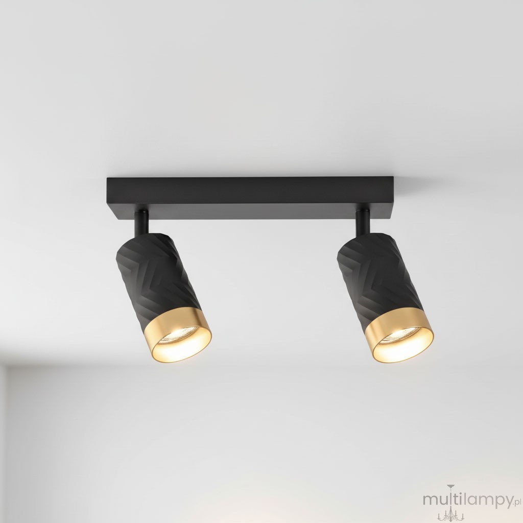 Lampa sufitowa Arras w kolorze czarnym i złotym z dwoma reflektorami GU10. Reflektory mają teksturowaną, czarną powierzchnię i złote obrzeża. Ujęcie z dołu, montowana na suficie, na jednolitym tle.