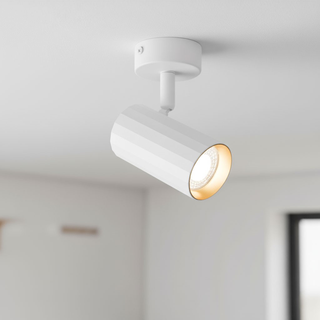 Lampa sufitowa Nicea w kolorze białym z złotym wnętrzem, w kształcie cylindrycznym, zamontowana na białym stropie. Ujęcie z boku, ukazuje skierowaną w dół żarówkę GU10. Tekstura lampy jest gładka z delikatnymi żłobieniami.