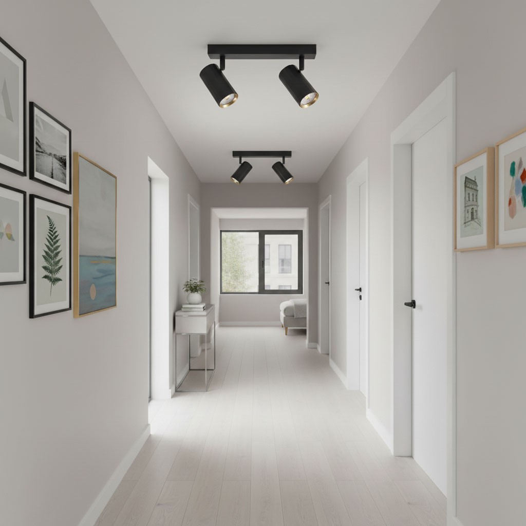 Lampa sufitowa Nicea w kolorze czarnym i złotym, z dwoma reflektorami GU10, zamontowana na suficie w jasnym korytarzu. Widoczne są również obrazy na ścianach oraz meble w tle.