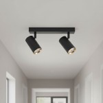 Lampa sufitowa Nicea w kolorze czarnym z złotymi akcentami, z dwoma reflektorami GU10 zamontowanymi na prostokątnej podstawie. Ujęcie frontalne, ukazujące detale lampy w nowoczesnym wnętrzu z jasnym tłem.