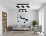 Lampa sufitowa Nicea z trzema reflektorami GU10 w kolorze czarnym i złotym, zamontowana na suficie. Reflektory mają cylindryczny kształt i są skierowane w różnych kierunkach. W tle widoczny nowoczesny salon z szaro-beżową sofą i drewnianymi regałami.