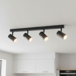 Czarna lampa sufitowa typu spot z czterema reflektorami GU10, zamontowana na prostokątnej, metalowej belce. Reflektory są skierowane w różne strony, a ich wykończenie ma złote detale. Produkt widoczny na jasnym tle kuchennym.