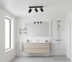 Czarna lampa sufitowa Turyn IP44 z trzema reflektorami GU10, zamontowana na białym suficie. Widoczna w nowoczesnej łazience z drewnianą szafką i szklanym prysznicem. Prosty, minimalistyczny design.
