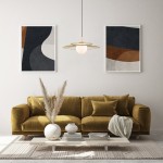 Złota lampa wisząca Sarah MDM-4000/1 GD z okrągłym szklanym kloszem, zawieszona nad brązową sofą. W tle abstrakcyjne grafiki w ramkach na jasnej ścianie. Stół z naturalnego drewna z dekoracjami i roślinami.