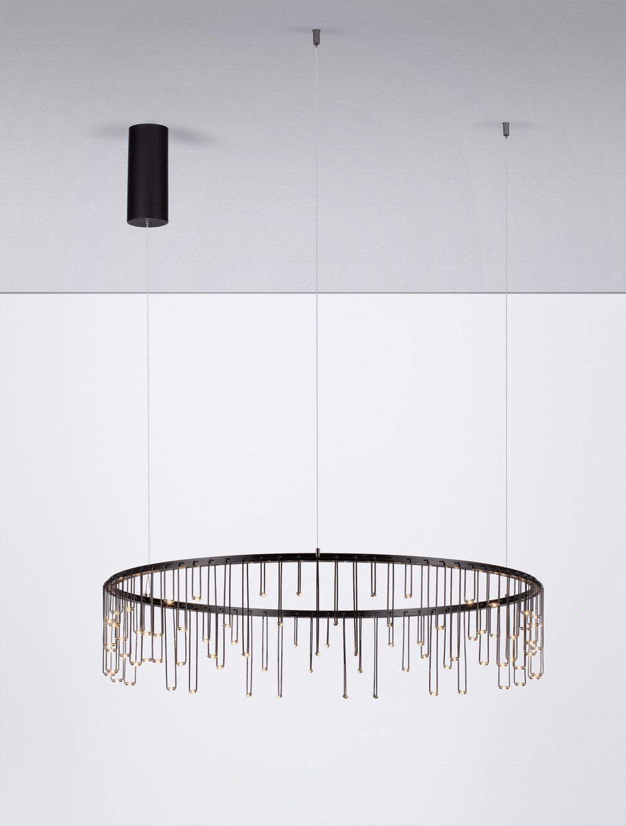 Czarna lampa wisząca Huaraz D80 z jednym źródłem światła LED 30W, w kształcie okrągłym, z cienkimi, wiszącymi elementami świetlnymi. Zawieszona na cienkich linkach, z okrągłym, minimalistycznym mocowaniem sufitowym. Tło białe.