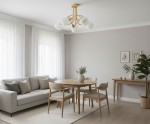 Lampa wisząca Eryka w kolorze złotym z pięcioma oprawami E14, z okrągłymi, białymi kloszami. Zawieszona na suficie w jasnym wnętrzu, nad drewnianym stołem i krzesłami, w otoczeniu roślin i dekoracji.