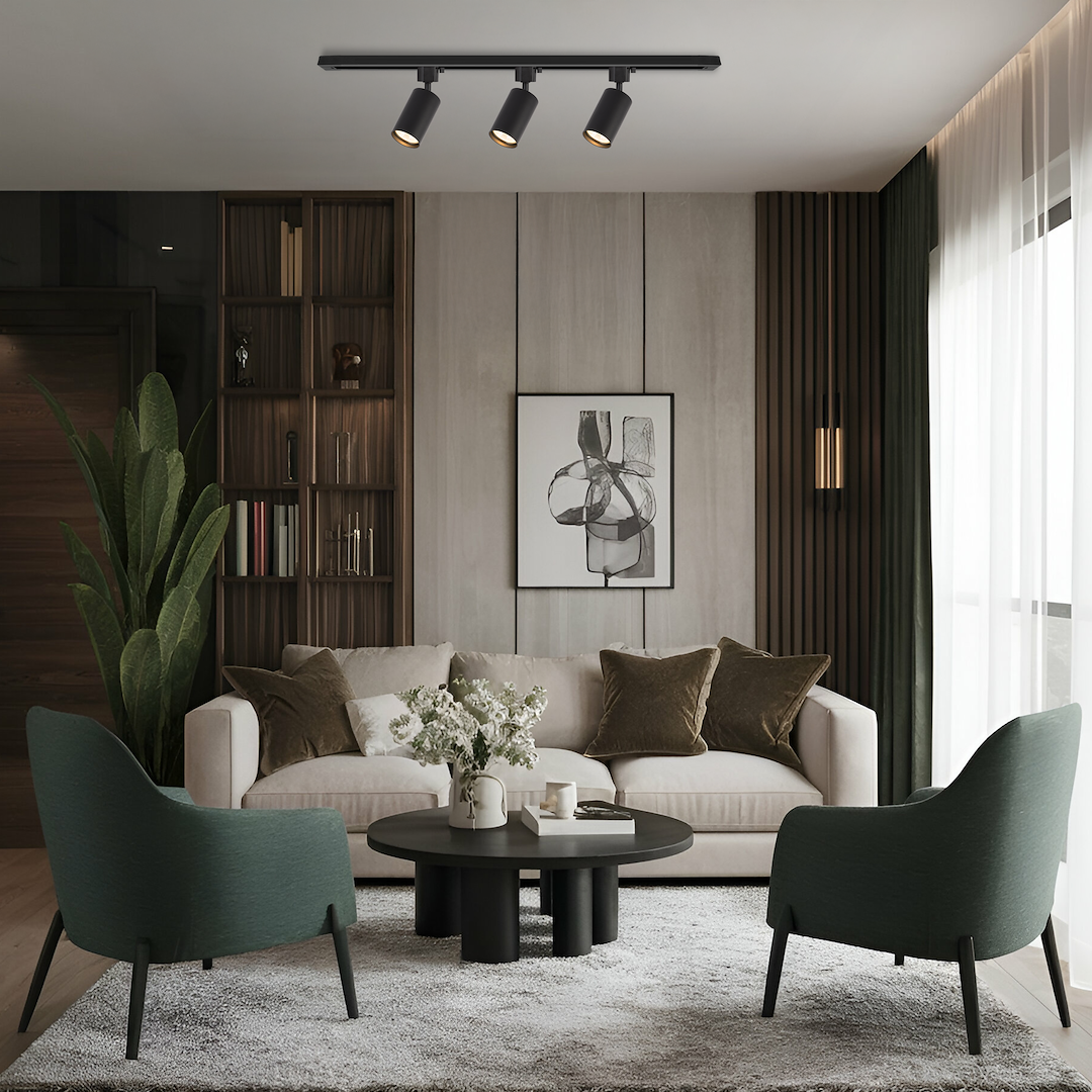 Zestaw szynowy 1m Tiger Track z trzema reflektorami GU10 w kolorze czarnym, montowany na suficie, z widocznymi detalami lamp i eleganckim wykończeniem. Produkt umieszczony w nowoczesnym wnętrzu, obok sofy i stolika kawowego.