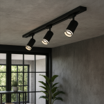 Zestaw szynowy 1m Pipe Ring Track z trzema reflektorami GU10 w kolorze czarnym, zamontowany na suficie, z widocznym wyposażeniem w minimalistycznym wnętrzu. Reflektory skierowane w stronę pomieszczenia, na tle szarej ściany i dużych okien.