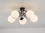 Czarna lampa sufitowa Banko z pięcioma okrągłymi kloszami w kolorze białym, zamontowana na suficie. Klosze umieszczone na metalowych ramionach tworzą nowoczesny design. Wymiary i szczegóły konstrukcji nie są widoczne.