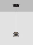 Lampa wisząca Huarmey z jednym źródłem LED 9W, w kolorze czarnym. Okrągła, szklana klosz w lekko przezroczystym wykończeniu zawieszona na dwóch czarnych linkach. Ujęcie z boku, na jednolitym tle.