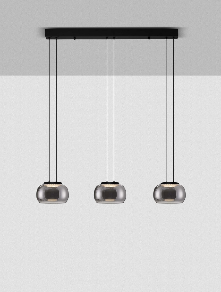 Lampa wisząca Huarmey z trzema kloszami LED w kolorze czarnym. Klosze mają przezroczyste, zaokrąglone kształty, zawieszone na cienkich linkach. Metalowa podsufitka w kolorze czarnym, prosta forma, idealna do nowoczesnych wnętrz.