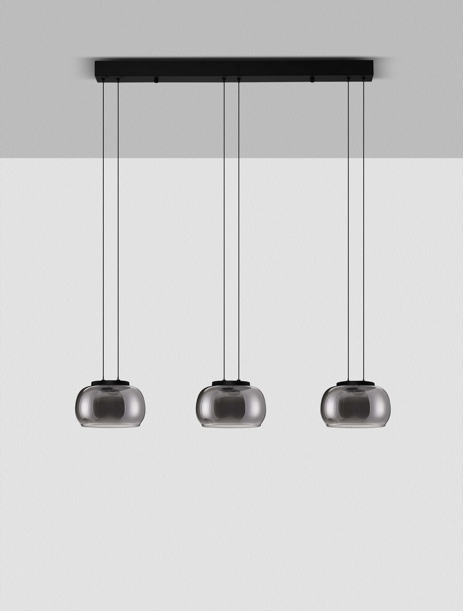 Lampa wisząca Huarmey 3xLED 25W w kolorze czarnym, z trzema szklanymi kloszami w kształcie owalnym, zawieszona na cienkich linkach. Klosze mają ciemnoszare wykończenie, montowana na czarnej podstawie sufitowej. Tło białe.