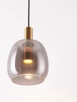 Lampa wisząca Iquitos z jednym źródłem LED 7W, z przezroczystym kloszem w kształcie kulistym i złotym mocowaniem. Produkt zawieszony na czarnym przewodzie, idealny do nowoczesnych wnętrz.