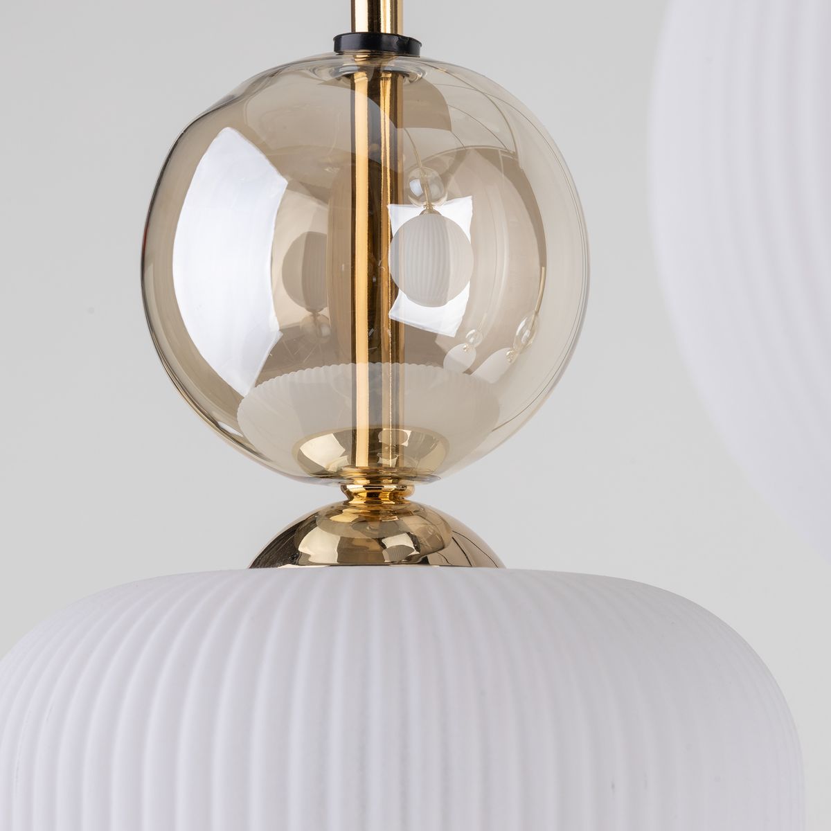 Lampa wisząca Sophia z sześcioma gniazdami E14, w kolorze białym. Złote detale oraz szklana kula tworzą elegancki design. Widoczne są białe, teksturowane klosze z żebrowaniem, a także złota podstawa. Produkt w zbliżeniu, na jednolitym tle.