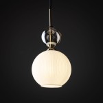 Lampa wisząca Sophia z kloszem w kształcie białej, matowej kuli z wypukłymi żłobieniami, umieszczona na złotej oprawie. Górna część z przezroczystego szkła. Ujęcie frontalne na ciemnym tle. Działa z żarówką E14.