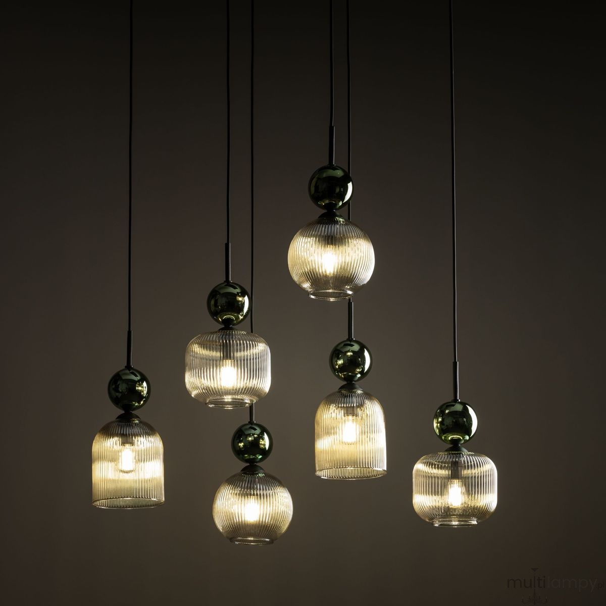 Lampa wisząca Sophia z sześcioma kloszami E14, w kolorze bursztynowym i zielonym. Klosze mają prążkowaną fakturę oraz kuliste, błyszczące elementy. Produkt zwisający na cienkich linkach, umieszczony na ciemnym tle.
