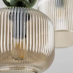 Lampa wisząca Sophia z sześcioma oprawami E14, w bursztynowym szkle z pionowymi żłobieniami, z zielonym elementem mocującym. Widok zbliżony na szklane klosze, ukazujący detale tekstury i kształtu.