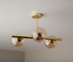 Złota lampa sufitowa Eral z trzema kulistymi kloszami. Ujęcie z dołu, pokazujące metalową konstrukcję i przezroczyste, lekko brązowe kulki. Lampa zamontowana do sufitu, w nowoczesnym stylu.
