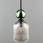 Lampa wisząca Sophia z kloszem w bursztynowym kolorze, z pionowymi żłobieniami. U góry znajduje się zielona, połyskująca kula, całość zawieszona na czarnym kablu. Produkt wisi w pozycji pionowej na szarym tle.