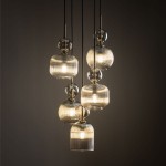 Lampa wisząca Sophia z pięcioma kloszami E14 w bursztynowym kolorze. Okrągłe, szklane elementy z delikatnym żłobieniem, zawieszone na czarnych linkach. Przyciągający wzrok design, idealna do nowoczesnych wnętrz.