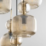 Lampa wisząca Sophia z pięcioma kloszami E14 w kolorze bursztynowym, z żłobieniami na powierzchni. Klosze mają różne kształty: prostokątny i okrągły, zawieszone na czarnych przewodach. Metalowe detale w złotym kolorze.
