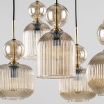 Lampa wisząca Sophia z pięcioma kloszami E14 w bursztynowym kolorze. Klosze mają żłobioną fakturę i okrągłe, przezroczyste elementy. Lampa zawieszona na czarnym przewodzie, w nowoczesnym stylu, idealna do aranżacji wnętrz.