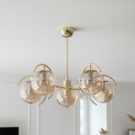 Lampa wisząca El Dorado 5-punktowa w złotym kolorze z przezroczystymi, kulistymi kloszami. Produkt zawieszony na cienkim stelażu, z metalowymi akcentami, umiejscowiony na białym tle. Wymiary i detale konstrukcyjne nie są widoczne.