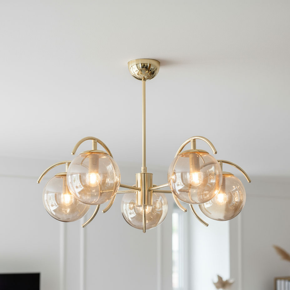 Lampa wisząca El Dorado 5-punktowa w kolorze złotym z pięcioma szklanymi kloszami, umieszczona na długim wysięgniku. Klosze mają okrągły kształt i są lekko przezroczyste, co nadaje efektownego blasku. Ujęcie z dołu, zawieszona na suficie.